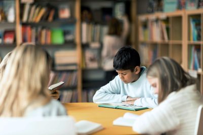 Elever på Noblaskolan sitter i skolbiblioteket och läser.