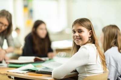 Elev sitter i ett klassrum och studerar.