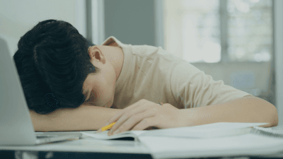 elev ligger ner på bänken och är trött