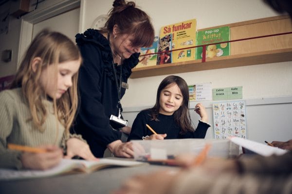 Elever och lärare som skriver.