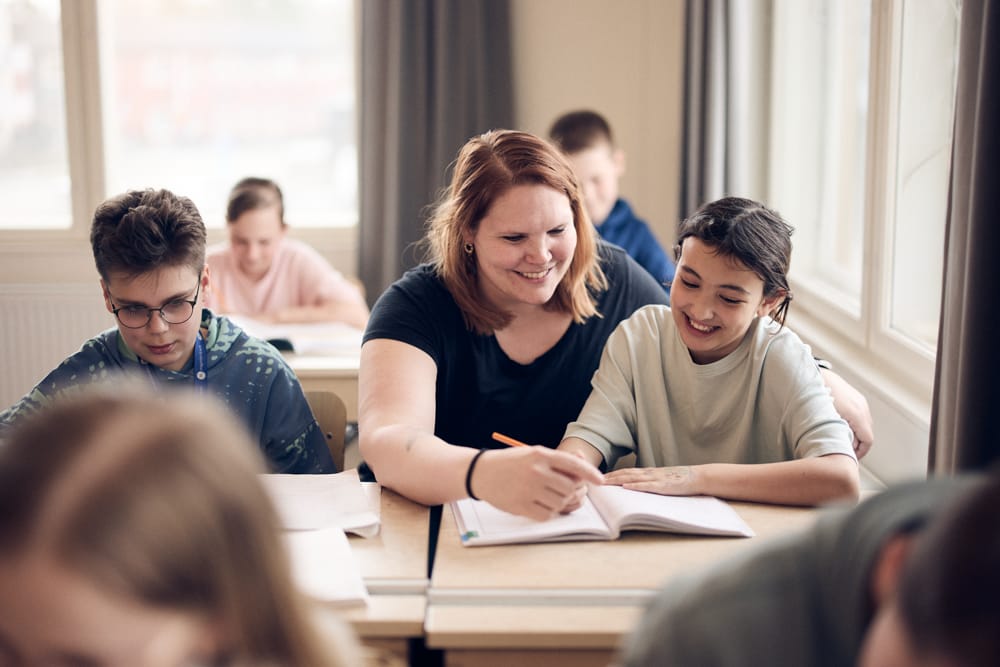 Lärare hjälper mellanstadieelev i klassrum på Noblaskolan.