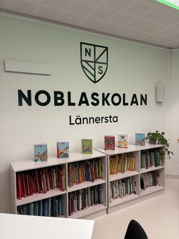 Skolans logga och en bokhylla