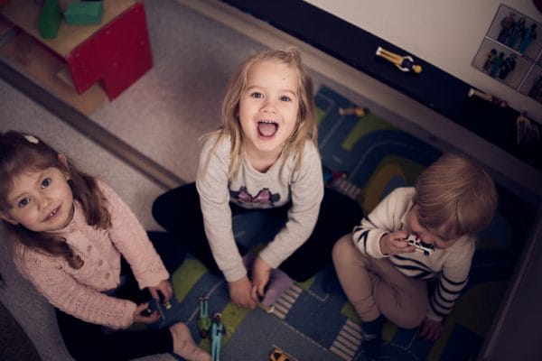 Barn som sitter på golvet.