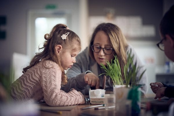 Elev och pedagog som pysslar.
