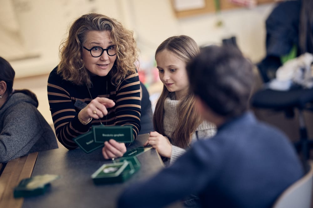 Lärare på Noblaskolan hjälper elev i klassrummet.
