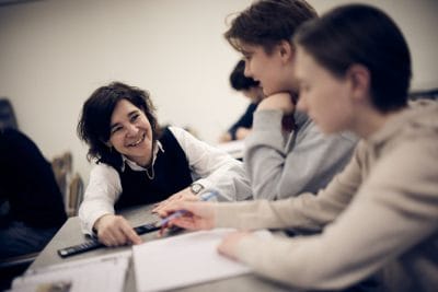 Lärare hjälper två elever vid bänken.