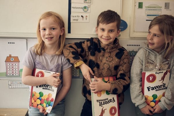 Elever som håller i läroböcker.