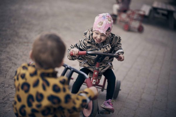 Tre elever som är ute och cyklar på skolgården.